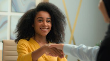 Aday insan kaynakları kiralayan Afrikalı Amerikalı mutlu iş kadını işvereni anlaşma sağladı. Kadın iş ortakları el sıkıştı. Müslüman kadın el sıkışması kadın ortaklığı hoş geldiniz.