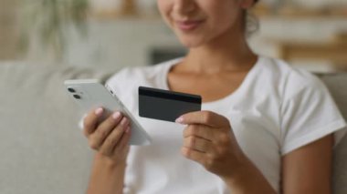 Mutlu gülümseyen Hintli kadın Arap kadın alıcı müşteri güvenli sayıda kredi kartı bankacılığı online cep telefonu alışverişi akıllı telefon satın alma uzaktan satın alma ev ödemeli internet girin