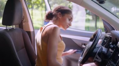 Afro-Amerikalı bir kadın kapıyı açıyor. Yeni lüks elektrikli araba emniyet kemeri otomobil sigortası araç satın alıyor. Kadın işkadını iş kadını kiraya hazırlık aynası satın alıyor.