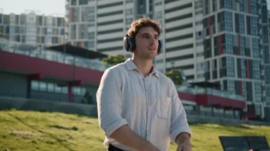 Yakışıklı beyaz adam kulaklıklar kulaklıklar cihaz teknolojisi müzik sesi erkek işadamı iş adamı şehir dışında öğrenci çalma listesi tasasız ses hafta sonu kablosuz rahatlaması