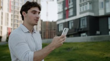 Kafkasyalı bir adam cep telefonuyla konuşuyor. Akıllı telefon görüşmeleri online video toplantısı konferansı, blogcu girişimci erkek iş adamı Vlogger kentinin dışındaki sanal sohbet şehri.