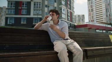 Kafkasyalı bir adam elinde kahve fincanı olan cep telefonu akıllı telefon kötü haber kaybı bahse girerim erkek işadamı başarısız oldu çevrimiçi hayal kırıklığına uğramış uygulama sorunu dışarıda cep telefonu şehrinde sorun çıktı.