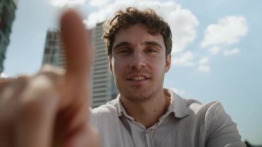 Beyaz adam internet sosyal medya ağlarını tıklatıyor POV webcam 'i tarıyor gülümsüyor erkek dokunmatik ekran AR akıllı telefon işadamı iş şehirini açık havada görüntülüyor