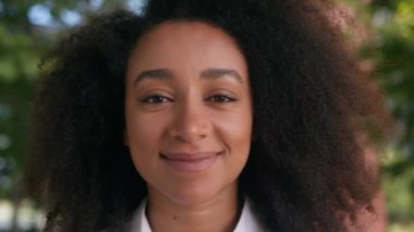 Kapalı yüzlü Afro-Amerikan kadın gülümseyen komik bayan iş kadını portresi mutlu öğrenci sağlık dişleri gülümsemesi kamera dişli iş şehrine bakan açık hava tıbbı