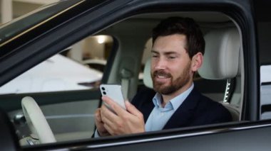 Kafkasyalı iş adamı yeni araba sahibi araba sahibi kullanıcı cep telefonu akıllı telefon internet sosyal ağlar güldüren komik iş adamı yetişkin kuaför dükkanında nakliye satın alıyor.