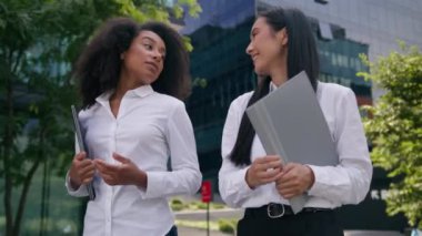 Çok ırklı, Afrikalı, Asyalı kadın, iş kadını, iş kadını, açık hava ortakları, müzakere anlaşması, iş arkadaşları, dosyalar, takım çalışması, iş arkadaşları, iş arkadaşları sohbetleri.