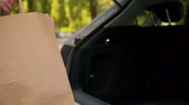 Bilinmeyen Kafkasyalı büyükanne alışverişçi kadın olgun araba sahibi müşteri müşteri müşteri kadın eller araba bagajı bagajı bagajları alışveriş çantaları dışarıda alışveriş çantaları.