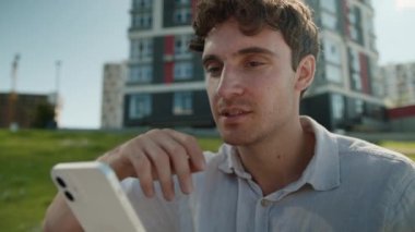 Beyaz adam ekrandaki cep telefonuna bakıyor akıllı telefon teknolojisi internetteki sohbet mesajları sosyal ağlar erkek işadamı iş adamı şehir içi iletişimi zımbırtısı.