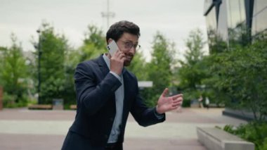 Kızgın, meşgul, Kafkasyalı iş adamı, öfkeli iş adamı, öfkeli adam, işe git, ofis binasına git, sinirli lider yatırımcı erkek, cep telefonuyla konuşmaya git, dışarıda buluşmayı tartış.