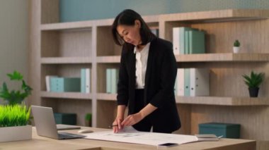 Asyalı iş kadını kız işkadını, mimar, tasarımcı, ofis işyerindeki masaya yazı yaz. Çinli Japon iş kadını not yazmayı planlıyor. Masa başı işlerini organize ediyor.