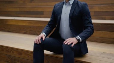 Endişeli Kafkas iş adamı orta yaşlı iş adamı merdivenlerde bekliyor. Sabırsız, sabırsız, şehirde üzgün bir erkek. Toplantı saatini kontrol et.