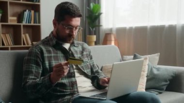 Kafası karışmış yetişkin bir adam, bilgisayar arızasını kullanarak internet üzerinden internet üzerinden alışveriş yapıyor, internet kartı alıyor, internet üzerinden para kazanıyor, e-ticaret yapıyor ve işlem hatası yapıyor.