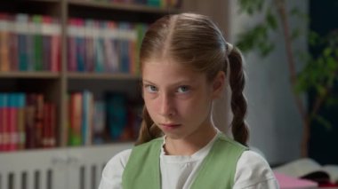 Üzgün, küçük, beyaz, liseli, depresyondaki öğrenci, mutsuz, öğrencilerden sıkılmış, kameraya bakıyor, sorunları inceliyor, eğitim zorbalığı, kapalı kütüphane sınıfında sorun öğreniyor.