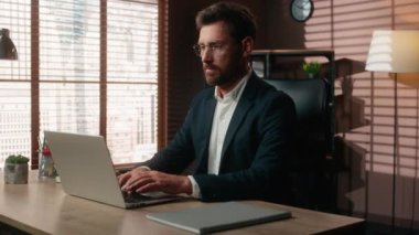 Konsantre olmuş internet işi Kafkasyalı orta yaşlı iş adamı yetişkin iş adamı ofiste çalışan erkek işveren masadaki dizüstü bilgisayar teknolojisi şirketi