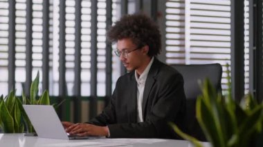 Mutlu şampiyon, başarılı Afrikalı Amerikalı iş adamı, işadamı, ofiste çalışan erkek işadamı, iş adamı, laptop kazan, iyi haberler al, online bildirim koltukta keyfine bak.