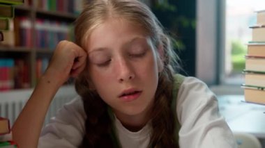Çaresiz, bezgin, yorgun, Kafkasyalı, tembel, küçük kız, çocuk, okul öğrencisi. İki büyük kitap yığını, çok çalışan okul kütüphanesi problemlerini araştırıyor.