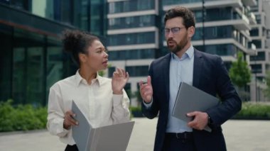 İki çok ırklı iş ortağı çok ırklı Afrika kökenli Amerikalı kadın kadın iş kadını Kafkasyalı erkek, erkek, iş adamı ve şehirde yürüyen iş adamıyla ciddi bir proje başlatılması hakkında konuşuyor.