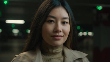 Asya kökenli etnik kadın Koreli 20 'li yaşlarda Japon Çinli iş kadını gülümsüyor. Kadın müşteriye bakıyor. Güzel kadın sürücü arabası sahibi yeraltı otoparkında poz veriyor.