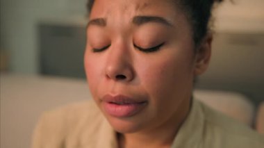 Üzgün, hastalıklı, hastalıklı, Afrikalı, Amerikalı, etnik kadın, sinirli, endişeli, düşünceli, depresyonlu ev sahibi, evde yalnız başına acı çeken bir kadın.