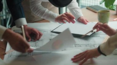 Ofis ekibi çok ırklı Hintli Müslüman iş arkadaşları kadın tasarımcılar, mimarlar mimarlar mimari yapı planını tartışanlar masa üzerine inşaat şeması çiziyorlar.