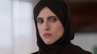 Sinirli İslami kadın etnik İslam kızı tesettür Arap tesettürlü endişeli üzgün gözlü kadın iş kadını kapalı mekanda hayal kırıklığına uğramış Arap kadın kamera sorunlu sağlık hizmetlerine bakıyor.