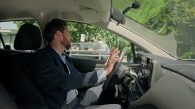 Kafkas erkek işadamı kendi arabasında şarkı söylüyor radyoda müzik dinliyor mutlu adam otomobil kullanıyor araba kullanıyor kaygısız neşeli adam kira alıyor modern elektrikli taşıma araçları satın alıyor kamera keyfine şarkı söylüyor