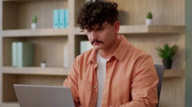 Kafkasyalı iş adamı, erkek, işadamı, ofis müdürü, iş yeri müdürü bilgisayarında çalışan, bilgisayarında çalışan, masa başında programlama okuyan, gülümseyen kameraya bakan iş adamı.