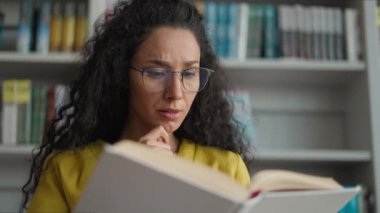 Hintli İspanyol kadın okuyucu, hazırlık sınavına hazırlanıyor. Kitap okuyor, liseli kız okuyor, okuyor, edebiyat okuyor, edebiyat bilgisi öğreniyor, kitaplık eğitimi alıyor.