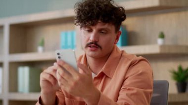 Kafkasyalı iş adamı girişimci erkek ofis çalışanı cep telefonu veri taraması internet cihaz bağımlılığı akıllı telefon mesajları yazma ödeme emri cep telefonu ekranı