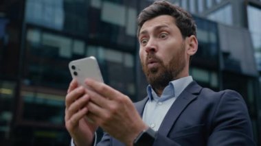 Kafkasyalı adam şaşırdı şaşırtıcı bir şekilde erkek işadamı mutlu iş adamı iş adamı cep telefonu mesajı inanılmaz haberler kazandı online kumar internet akıllı telefon uygulaması açık havada