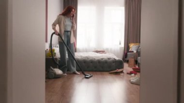 Kızgın beyaz kadın ev hanımı hayal kırıklığına uğramış ev hanımı kadın ev hanımı konuşuyor cep telefonu kavgası yatak odasındaki dağınıklık yerleri süpürme süpürge temizlik ev temizliği stresli ev işi