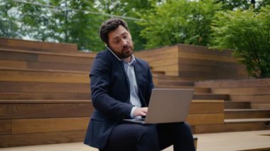 Kafkasyalı meşgul girişimci erkek işadamı. Akıllı telefon görüşmesi. Konuşan cep telefonu görüşmesi. Çevrimiçi, bilgisayarlı, uzaktan kumandalı konuşma.