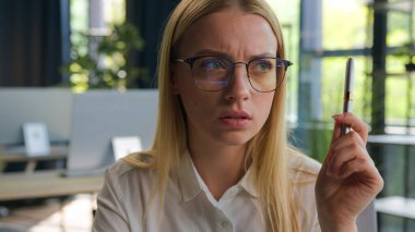 Düşünceli, kafası karışmış, gözlüklü, beyaz, iş kadını bir kızın portresi. İş fikri, yaratıcı düşünceler. Düşünceli kadın çözümleri, ofis beyin fırtınası sorununu çözer.