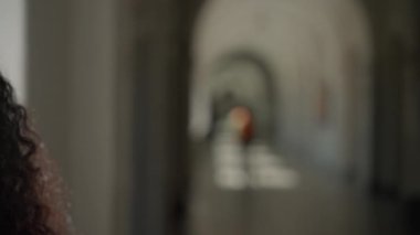 Mutlu gülümseyen bir portre güzel etnik kadın öğrenci Latin bayan üniversite akademisi koridorunda kapalı alanda beyaz bir kadınla yüzleşiyor kamera vesikalığı eğitimine gülümsüyor
