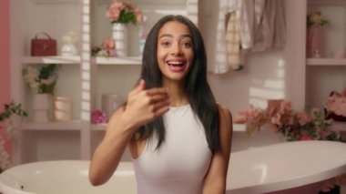 Neşeli, Latin, pozitif kadın, Latin kökenli, mutlu, gülümseyen, hoş geldin, el hareketi yapan, tuvalet oteline davet edilen, güzellik, cilt, doğal, sağlıklı, çekici, küvet kaplıcaları.