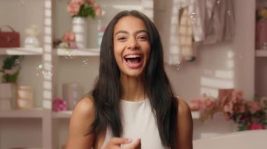 Mutlu kadın Latin kız sağlıklı güzel bayan kameraya bakıyor romantik otel banyosu baloncukları şampuan jel spa prosedürü güzellik cilt pozitif kahkaha