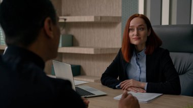 Çok ırklı Afrika kökenli Amerikalı iş adamı ve Kafkasyalı iş kadını çeşitli meslektaşları, ortak iş danışmanlığı ile çevrimiçi finans projesini tartıştılar.