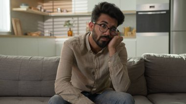 Düşüncelere dalmış, derin düşüncelere dalmış düşünceli Hintli Arap bir adam yorgun, yorgun, endişeli, sıkıcı bir erkek hafta sonu baş ağrısı sorunu çözümü depresyonu yaşıyor.