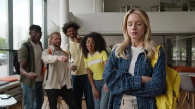 Üniversite koleji kabadayılığı. Çok ırklı dört çoklu etnik öğrenciyle alay eden kötü zorba alay ediyor. Üzgün, yalnız, beyaz kadın çalışmasını işaret ederek alay ediyorlar.