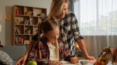 Kafkasyalı küçük öğrenci kız çocuğu, ev ödevi eğitimi alan kız çocuğu, kopya kitabı yazan, ailesini seven kadın anne, anne, baba, çocuk öğrenci, aile içi öğrenime dokunan kız çocuğu.