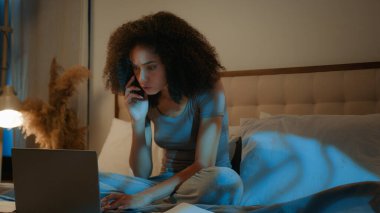 Öfkeli Afrikalı Amerikalı kadın iş kadını evde dizüstü bilgisayarlı kağıtlarla çalışıyor cep telefonuyla ilgili çılgınca konuşmalar, aşırı mesai, belgesel, akıllı telefon çığlıkları ve tartışmalarla ilgili sorunlar.