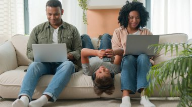 Bağımlı aile araç gereçleri kullanıyor. Küçük çocuk çocuk koltukta baş aşağı yatıyor. Cep telefonunda video oyunu oynuyor.