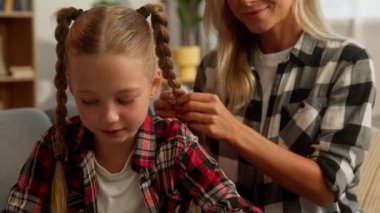 Neşeli aile, beyaz kadın anne, saç örüyor, küçük kız, çocuk, anne, saç stili, küçük kız çocuğu, saç kesimi, saç kesimi, annelik bağı.