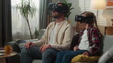 Beyaz bir aile sanal gerçeklik oyunu oynuyor. 3D gözlüklü kasklar takıyor. VR modern teknolojiyi evde yaşıyor.