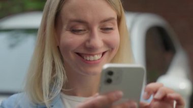 Şaşırtıcı neşe dolu Kafkasyalı kadın araba sahibi, ekran ekranı sahibi, cep telefonu satıcısı, iş kadını, şehirde kazanan, mutlu bayan, mutlu, gülümseyen, otomobil kiralama uygulaması.