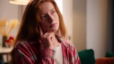 Kafkasyalı, düşünceli, kızıl saçlı, evde düşünen bir kadın. Düşünceli, düşünceli, düşünceli bir kadın. Dairede karar verme konusunda tereddütlü, düşünceli, Avrupalı bir kadın.