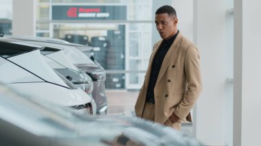 Afro-Amerikalı iş adamı otomobil gülümseyen müşteri alıcısını seçiyor. Milenyum adamı otomobil galerisinde lüks modern araba almayı hayal ediyor.