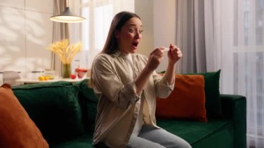 Heyecanlı, mutlu, beyaz kadın hamile kadın hamile bayanın sevinç çığlıkları evde iyi haberi kutluyor koltukta hamilelik testi pozitif gebelik testi doğurganlık, doğum tıbbı, gelecekteki aile reçetesi.