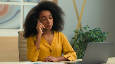 Üzgün kadın Afrikalı Amerikalı iş kadını ofis müdürü iş adamı CEO kız cep telefonu konuşmasından rahatsız olmuş danışma müvekkilinden rahatsız olmuş bilgisayarlı telefonlara cevap ver akıllı telefon
