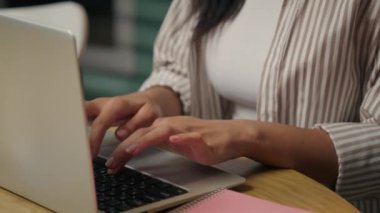 Yoğunlaştırılmış Arap Latin iş kadını kız Hintli etnik kadın serbest iş kadını dizüstü bilgisayarına göz atıyor internet siparişi veriyor internetten yemek dağıtımı daktilo yazıp ev mutfağı eğitimi alıyor.